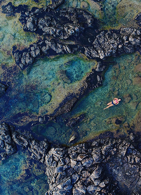 Cove with girl swimming in Oahua island in the Central Pacific