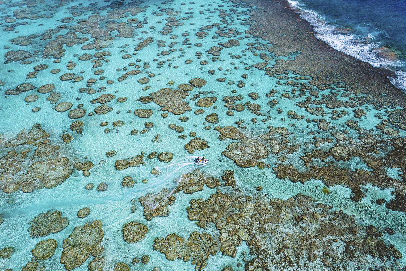 Ocean with shallow coral reefs in Tahiti island in French Polynesia